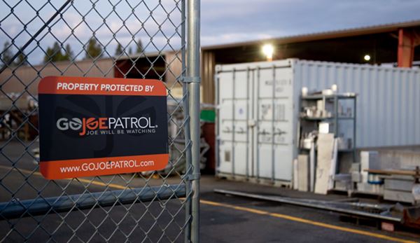 Photo of construction site with a mounted GoJoe Patrol sign on chainlink fence.