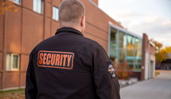 Photo of GoJoe Patrol security officer standing outside red brick building.